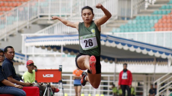 Atlet Maria Natalia Londa asal Bali melakukan lompatan pada final lompat jangkit senior putri dalam Kejuaraan Nasional Atletik 2019 di Stadion Pakansari, Cibinong, Jawa Barat, Rabu (7/8). [Antara/Yulius Satria Wijaya]