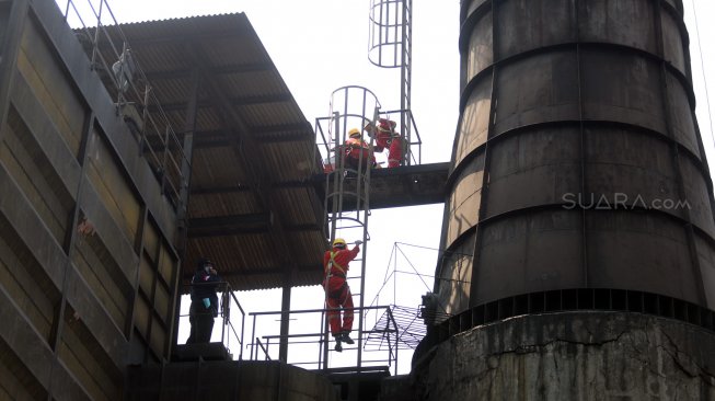 Petugas Dinas Lingkungan Hidup DKI Jakarta melakukan inspeksi terhadap pabrik yang memiliki cerobong asap di kawasan Pulogadung, Jakarta Timur, Kamis (8/8). [Suara.com/Arya Manggala]