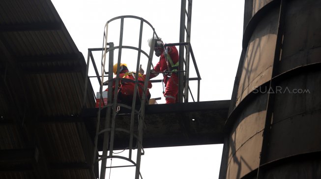 Petugas Dinas Lingkungan Hidup DKI Jakarta melakukan inspeksi terhadap pabrik yang memiliki cerobong asap di kawasan Pulogadung, Jakarta Timur, Kamis (8/8). [Suara.com/Arya Manggala]