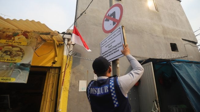 Petugas Dishub DKI Jakarta memasang rambu-rambu perluasan ganjil genap di kawasan Jalan Gunung Sahari, Jakarta, Jumat (9/8). [Suara.com/Arya Manggala]
