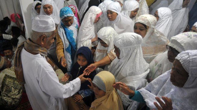 Jamaah Tarekat Naqsabandiyah bersalaman dengan khatib usai melaksanakan Shalat Idul Adha di Mushalla Baitul Makmur, Pauh, Padang, Sumatera Barat, Sabtu (10/8). [ANTARA FOTO/Iggoy el Fitra]