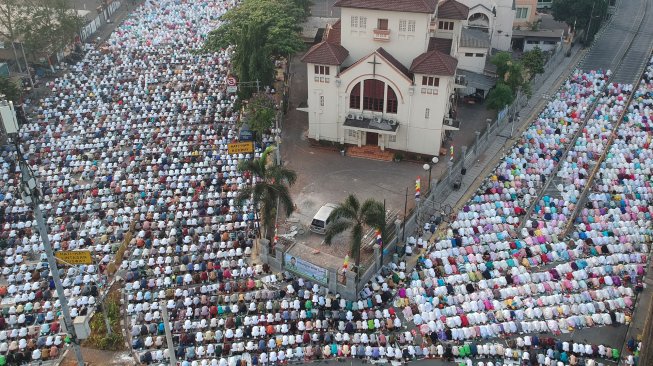 Umat Muslim menjalankan salat Idul Adha 1440 H di sekitar Gereja Koinonia, Jalan Matraman Raya, Jatinegara, Jakarta, Minggu (11/8). [Suara.com/Arya Manggala] 