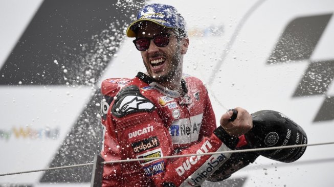 Rider Ducati, Andrea Dovizioso melakukan selebrasi di podium Sirkuit Red Bull Ring, usai memenangi MotoGP Austria 2019, Minggu (11/8) malam WIB. [AFP/Vladimir Simicek]