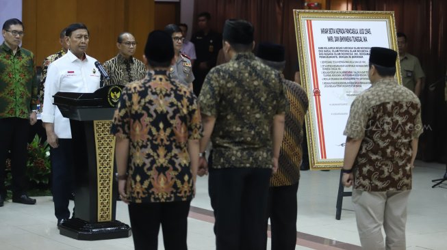 Keluarga besar Harokah Islam Indonesia, eks DI/TII dan eks NII membacakan ikrar setia kepada Pancasila, UUD 1945, dan Bhinneka Tunggal Ika di Kantor Kemenko Polhukam, Jakarta, Selasa (13/8). [Suara.com/Arya Manggala]