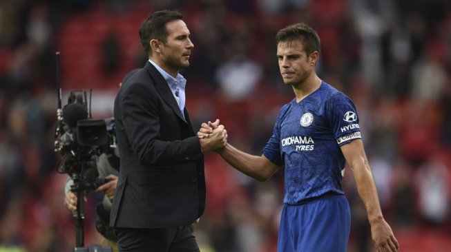 Kapten Chelsea, Cesar Azpilicueta (kanan) dan sang pelatih, Frank Lampard usai laga pekan perdana Liga Inggris 2019/2020 kontra Manchester United di Old Trafford, Minggu (11/8/2019) malam WIB. [Oli SCARFF / AFP]