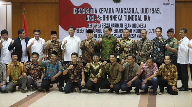 Keluarga besar Harokah Islam Indonesia, eks DI/TII dan eks NII berfoto bersama dengan menteri Polhukam Wiranto saat  ikrar setia kepada Pancasila, UUD 1945, dan Bhinneka Tunggal Ika di Kantor Kemenko Polhukam, Jakarta, Selasa (13/8). [Suara.com/Arya Manggala]