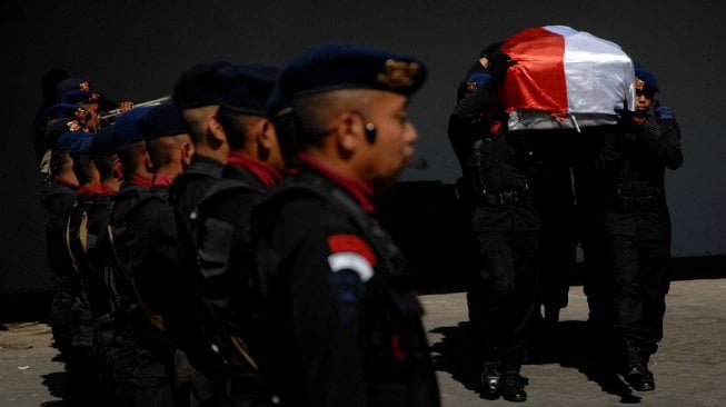 Anggota Polri mengusung peti berisi jenazah Briptu Hedar (24) yang menjadi korban penculikan dan penembakan kelompok kriminal bersenjata (KKB) saat tiba di Bandara Internasional Sultan Hasanuddin, Kabupaten Maros, Sulawesi Selatan, Selasa (13/8). [ANTARA FOTO/Abriawan Abhe]