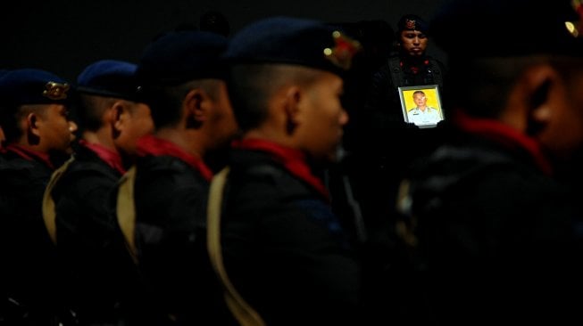 Anggota Polri mengusung peti berisi jenazah Briptu Hedar (24) yang menjadi korban penculikan dan penembakan kelompok kriminal bersenjata (KKB) saat tiba di Bandara Internasional Sultan Hasanuddin, Kabupaten Maros, Sulawesi Selatan, Selasa (13/8). [ANTARA FOTO/Abriawan Abhe]