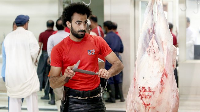 Mohammad Ibraheem saat memotong daging di sebuah rumah jagal hewan di hari ketiga Idul Adha di Kota Kuwait, Selasa (13/8). [AFP Photo/ Yasser Al-Zayyat]