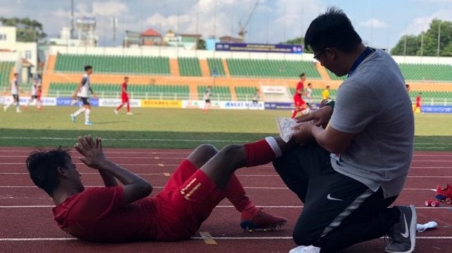 Pemain tengah timnas sepak bola U-18 Mochammad Supriadi dalam penanganan medis akibat mengalami cedera pergelangan kaki kanan saat bertanding melawan Laos dalam kejuaraan Piala AFF U-18 2018 di Ho Chi Minh City, Vietnam, Senin. (antaranews/roy rosa bachtiar)