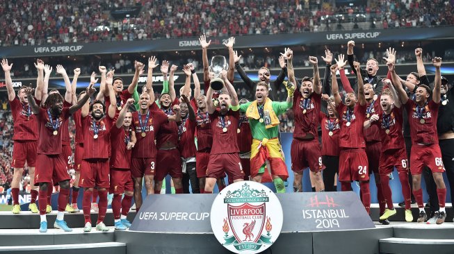 Para pemain Liverpool merayakan kemenangannya di podium setelah memenangkan pertandingan sepak bola UEFA Super Cup 2019 antara Liverpool melawan Chelsea di Stadion Besiktas Park, Istanbul, Turki, Kamis (15/8) dini hari WIB. [OZAN KOSE / AFP]