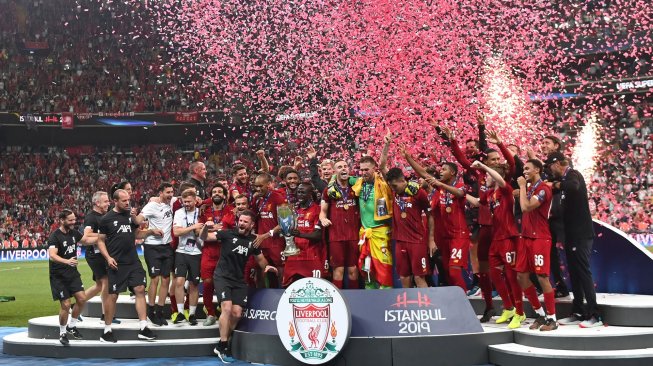 
Para pemain Liverpool merayakan kemenangannya di podium setelah memenangkan pertandingan sepak bola UEFA Super Cup 2019 antara Liverpool melawan Chelsea di Stadion Besiktas Park, Istanbul, Turki, Kamis (15/8) dini hari WIB. [Bulent Kilic / AFP]