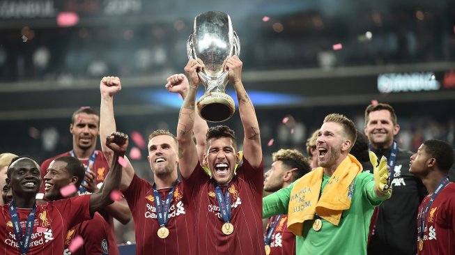 Para pemain Liverpool merayakan kemenangannya di podium setelah memenangkan pertandingan sepak bola UEFA Super Cup 2019 antara Liverpool melawan Chelsea di Stadion Besiktas Park, Istanbul, Turki, Kamis (15/8) dini hari WIB. [OZAN KOSE / AFP]