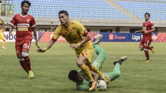 Pesepakbola Bhayangkara FC, Ramiro Fergonzi (tengah) berduel dengan kiper Perseru Badak Lampung FC, Daryono (tengah bawah) pada laga lanjutan Liga 1 2019 di Stadion Patriot, Bekasi, Jum'at (16/8/2019) sore. [ANTARA FOTO/Fakhri Hermansyah]