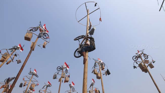 Warga mengikuti lomba panjat pinang kolosal dalam rangka HUT ke-74 Kemerdekaan RI di Pantai Karnaval, Ancol, Jakarta, Sabtu (17/8). [Suara.com/Arya Manggala]