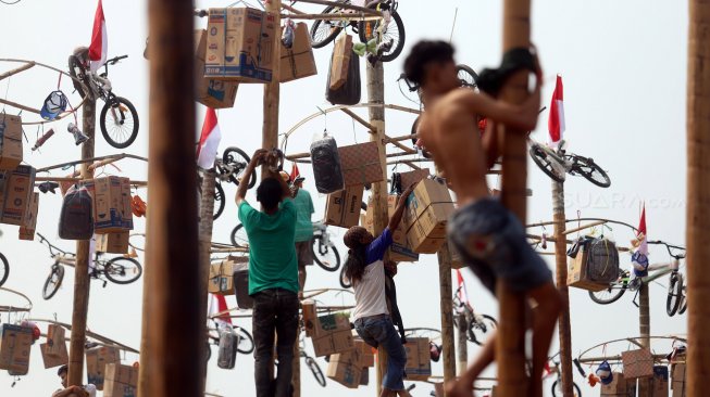 Warga mengikuti lomba panjat pinang kolosal dalam rangka HUT ke-74 Kemerdekaan RI di Pantai Karnaval, Ancol, Jakarta, Sabtu (17/8). [Suara.com/Arya Manggala]