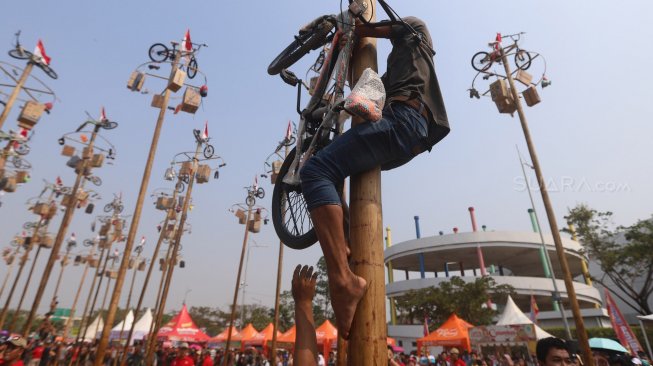 Warga mengikuti lomba panjat pinang kolosal dalam rangka HUT ke-74 Kemerdekaan RI di Pantai Karnaval, Ancol, Jakarta, Sabtu (17/8). [Suara.com/Arya Manggala]