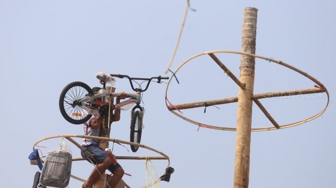 Warga mengikuti lomba panjat pinang kolosal dalam rangka HUT ke-74 Kemerdekaan RI di Pantai Karnaval, Ancol, Jakarta, Sabtu (17/8). [Suara.com/Arya Manggala]