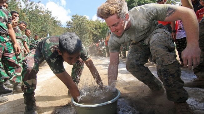 Prajurit Korps Marinir TNI AL dan Marinir Amerika Serikat (USMC) mengikuti perlombaan memindahkan belut memeriahkan HUT ke-74 Kemerdekaan RI di Hutan Selogiri, Ketapang, Banyuwangi, Jawa Timur, Sabtu (17/8).  [ANTARA FOTO/Budi Candra Setya]