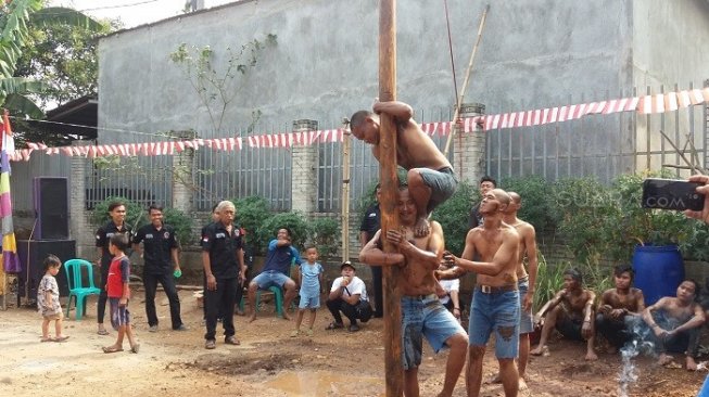 Pasien sakit jiwa lomba panjat pinang dengan warga. (Suara.com/M. Yacub).