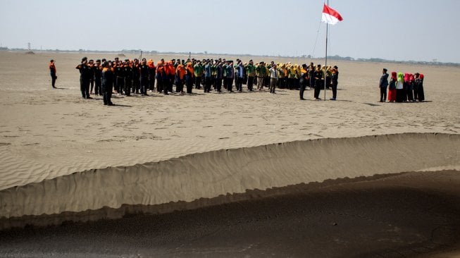 Suasana upacara bendera HUT ke-74 Kemerdekaan Republik Indonesia di kawasan lumpur titik 25, Porong, Sidoarjo, Jawa Timur, Sabtu (17/8). [ANTARA FOTO/Umarul Faruq]