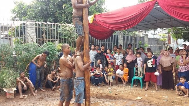 Pasien sakit jiwa lomba panjat pinang dengan warga. (Suara.com/M. Yacub).