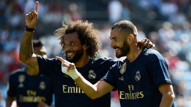 Penyerang Real Madrid, Karim Benzema (kanan) merayakan golnya ke gawang Celta Vigo bersama fullback Marcelo, dalam laga jornada pertama Liga Spanyol 2019/2020 di Balaidos, Sabtu (17/8/2019) malam WIB. [MIGUEL RIOPA / AFP]