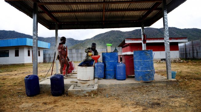 Petugas melayani warga yang membeli BBM di SPBU Kompak, Kampung Obano, Distrik Paniai Barat, Papua, Kamis (29/11/2018).