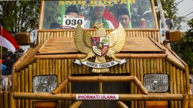 Sejumlah warga mengikuti karnaval mobil hias kemerdekaan di jalan RE Martadinata, Purwakarta, Jawa Barat, Sabtu (17/8/2019). Peserta karnaval dengan berbagai kreasi kendaraan hias berasal dari instansi pemerintah, kelompok seni, masyarakat dan perusahaan swasta dalam rangka peringatan HUT ke-74 Kemerdekaan RI [ANTARA FOTO/M Ibnu Chazar/wsj].