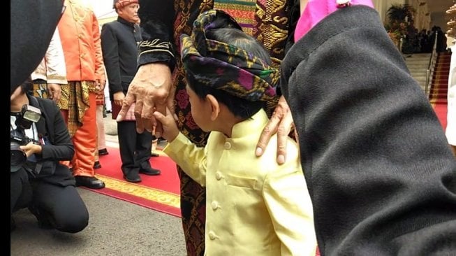 Jan Ethes genggam erat jari Jokowi usai pengibaran bendera merah putih di Istana Negara. (Suara.com/Ummy Hadyah Saleh).