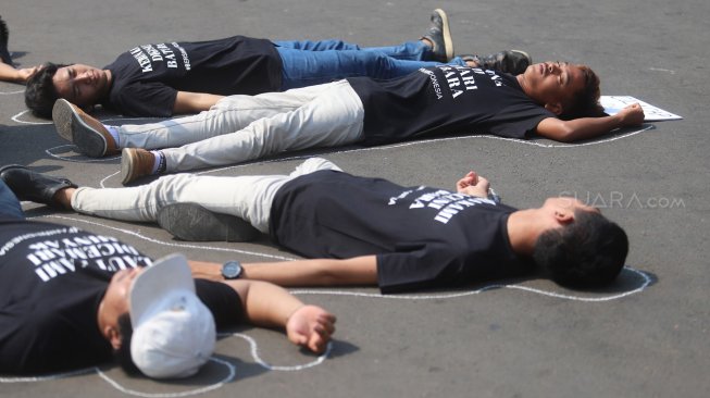 Sejumlah aktivis melakukan aksi berbaring #Bersihkan Indonesia di depan Istana Merdeka, Jakarta, Senin (19/8). [Suara.com/Arya Manggala]