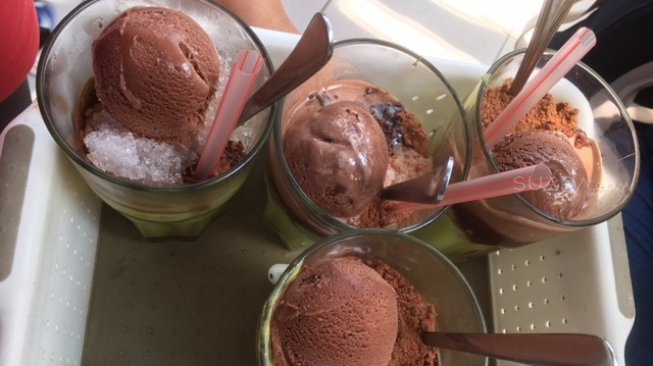 Avocado Coffee Float bikin ngiler, dengan satu scoop cokelat, serbuk cokelat dan muisjes di atas avokad warna hijau dan diguyur kopi espresso [Suara.com/ukirsari].