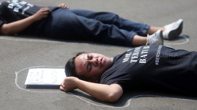 Sejumlah aktivis melakukan aksi berbaring #Bersihkan Indonesia di depan Istana Merdeka, Jakarta, Senin (19/8). [Suara.com/Arya Manggala]