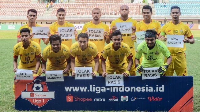 Sejumlah pemain Bhayangkara FC berfoto dengan poster seruan tolak rasisme saat lanjutan Liga 1 di Stadion Patriot Chandrabhaga, Bekasi, Jawa Barat, Selasa (20/8/2019). Aksi tersebut untuk solidaritas untuk menghentikan rasisme, diskriminasi dan kekerasan terhadap warga Papua. ANTARA FOTO/ Fakhri Hermansyah