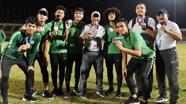 Pelatih Timnas U-18 Indonesia Fakhri Husaini (tengah) melakukan foto bersama dengan pemainnya saat penyerahan medali Piala AFF U-18 di Stadion Thong Nhat Ho Chi Minh, Vietnam, Senin (19/8). [ANTARA FOTO/Yusran Uccang]