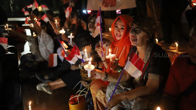 Massa yang tergabung dalam Pencinta NKRI dan Pancasila menggelar doa bersama untuk Papua di Tugu Proklamasi, Menteng, Jakarta, Selasa (20/8) malam. [Suara.com/Arya Manggala]