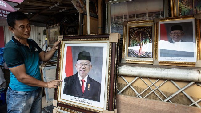 Pedagang merapikan poster Wakil Presiden terpilih Ma'ruf Amin yang dijualnya di kawasan Sawah Besar, Jakarta, Rabu (21/8). [ANTARA FOTO/Aprillio Akbar]