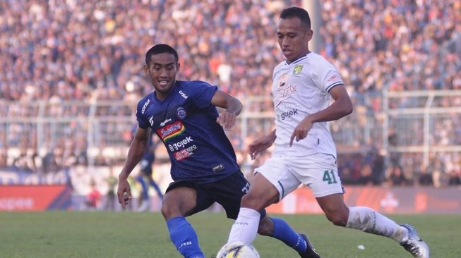 Pemain Arema FC membayangi penyerang Persebaya Surabaya dalam lanjutan Liga 1 2019 di Stadion Kanjuruhan, Malang, Kamis (15/8/2019). (Instagram/@aremaofficial)