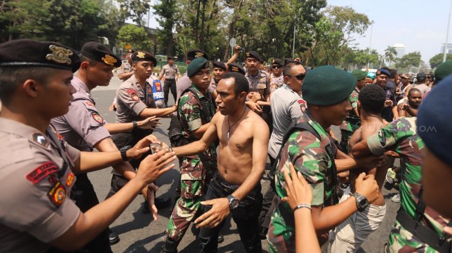 Sejumlah pemuda dan mahasiswa asal Papua terlibat saling dorong dengan aparat keamanan saat melakukan aksi unjuk rasa di kawasan Monas, Jakarta, Kamis (22/8). [Suara.com/Arya Manggala]