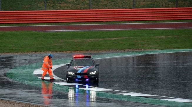 Pengawas lomba mengecek kondisi Sirkuit Silverstone yang menjadi tuan rumah MotoGP Inggris 2018 sebelum akhirnya balapan tersebut dibatalkan karena cuaca. Minggu (26/8). [AFP/Oli Scarff]