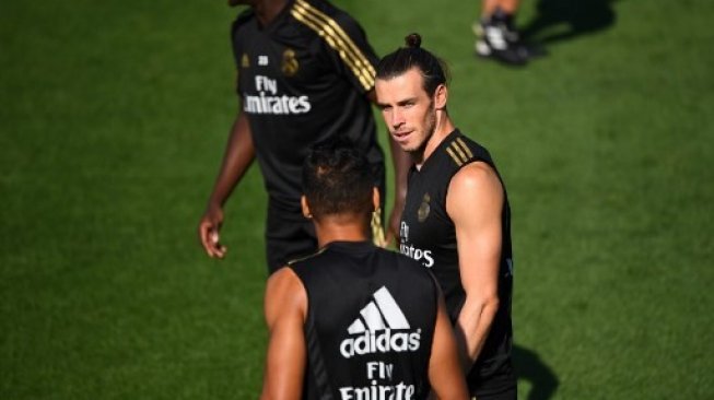 Pemain Real Madrid Gareth Bale (tengah) berbincang dengan rekannya di tengah sesi latihan Real Madrid di Real Madrid Sports City [AFP]