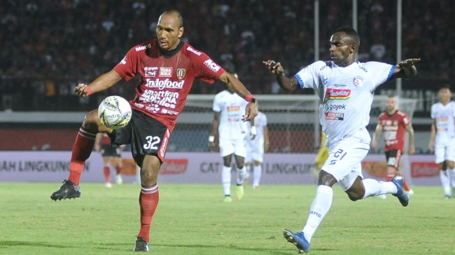 Pesepak bola Bali United Leonard Tupamahu (kiri) berebut bola dengan pesepak bola Arema Riky Kayame (kanan) saat pertandingan Liga 1 2019 di Stadion I Wayan Dipta, Gianyar, Bali, Sabtu (24/8/2019). ANTARA FOTO/Fikri Yusuf/wsj.