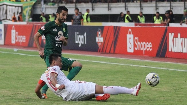 Pesepak bola Persebaya Manuchehr Jalilov (kiri) dihalau pesepak bola Persija Maman Abdurahman (kanan) saat pertandingan Liga 1 2019 di Stadion Gelora Bung Tomo, Surabaya, Jawa Timur, Sabtu (24/8/2019). Pertandingan tersebut berakhir imbang dengan skor 1-1. ANTARA FOTO/Moch Asim/wsj.