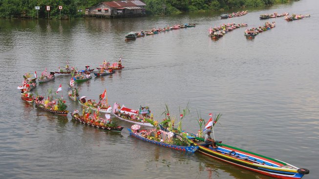 Sejumlah pedagang pasar terapung ditarik menggunakan kelotok (perahu bermesin) melintas di sungai Martapura menuju tempat pelaksanaan Festival Wisata Budaya Pasar Terapung di kawasan Tugu 0 Km Banjarmasin, Kalimantan Selatan, Jumat (23/8). [ANTARA FOTO/Bayu Pratama]