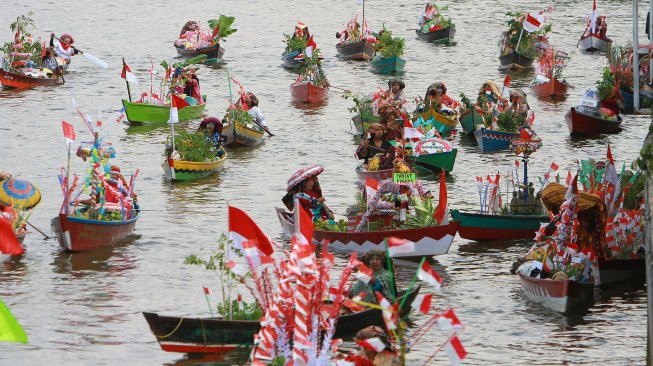 Sejumlah pedagang pasar terapung ditarik menggunakan kelotok (perahu bermesin) melintas di sungai Martapura menuju tempat pelaksanaan Festival Wisata Budaya Pasar Terapung di kawasan Tugu 0 Km Banjarmasin, Kalimantan Selatan, Jumat (23/8). [ANTARA FOTO/Bayu Pratama]