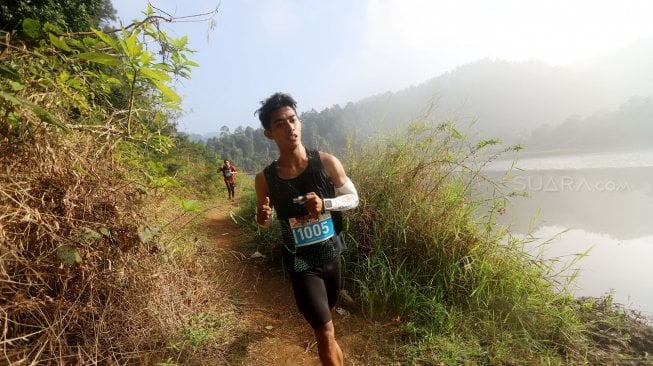 Pelari saat mengikuti Situ Gunung Trail Run (SGTR) 2019 di Situ Gunung, Sukabumi, Jawa Barat, Minggu (25/8).  [Suara.Com/Oke Atmaja]