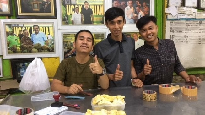 Abang-bang yang tampan ini siap membungkus durian yang hendak dibawa pulang sebagai oleh-oleh [Suara.com/ukirsari].