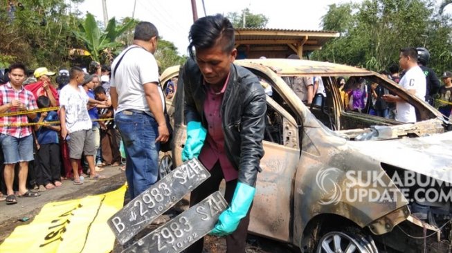 Polisi saat melakukan olah TKP terkait dua mayat di sebuah mobil terbakar. (Sukabumiupdate.com).