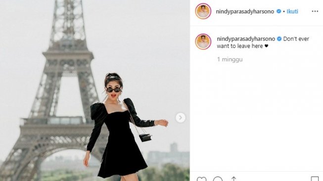 OOTD monokrom Nindy dengan latar Menara Eiffel. (Instagram/@nindyparasadiharsono)