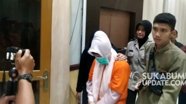 Penampakan Aulia Kusuma (35), istri muda pembakar suami dan anak tiri setelah ditetapkan sebagai tersangka. (sukabumiupdate.com).